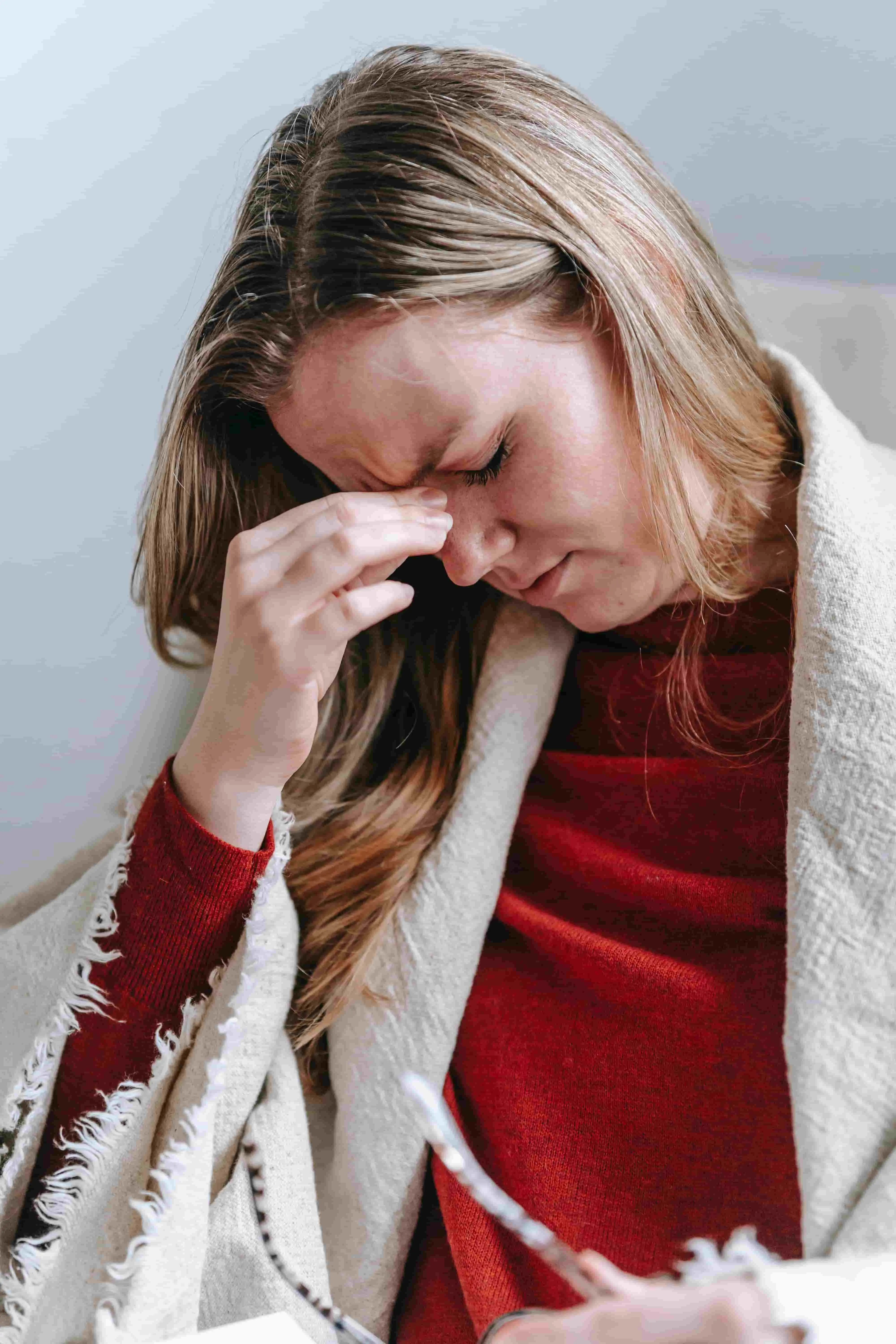 Women holding bridge of nose as she suffers from a migraine